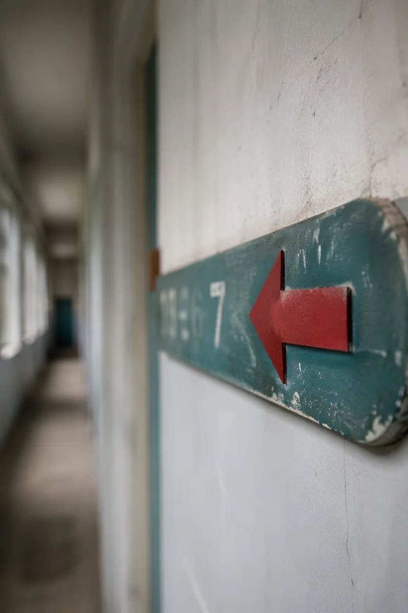 Red Arrow Direction Sign in Quiet Corridor