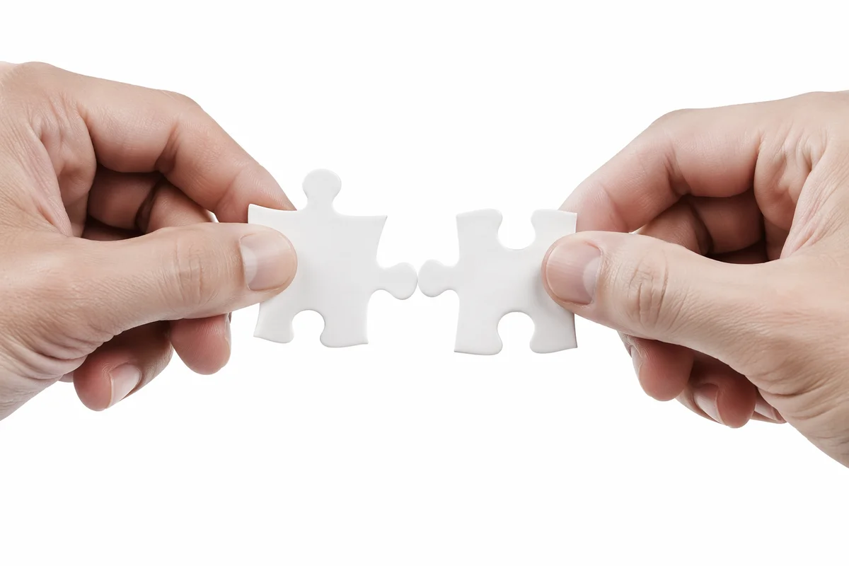 Hands Joining White Puzzle Pieces for Teamwork