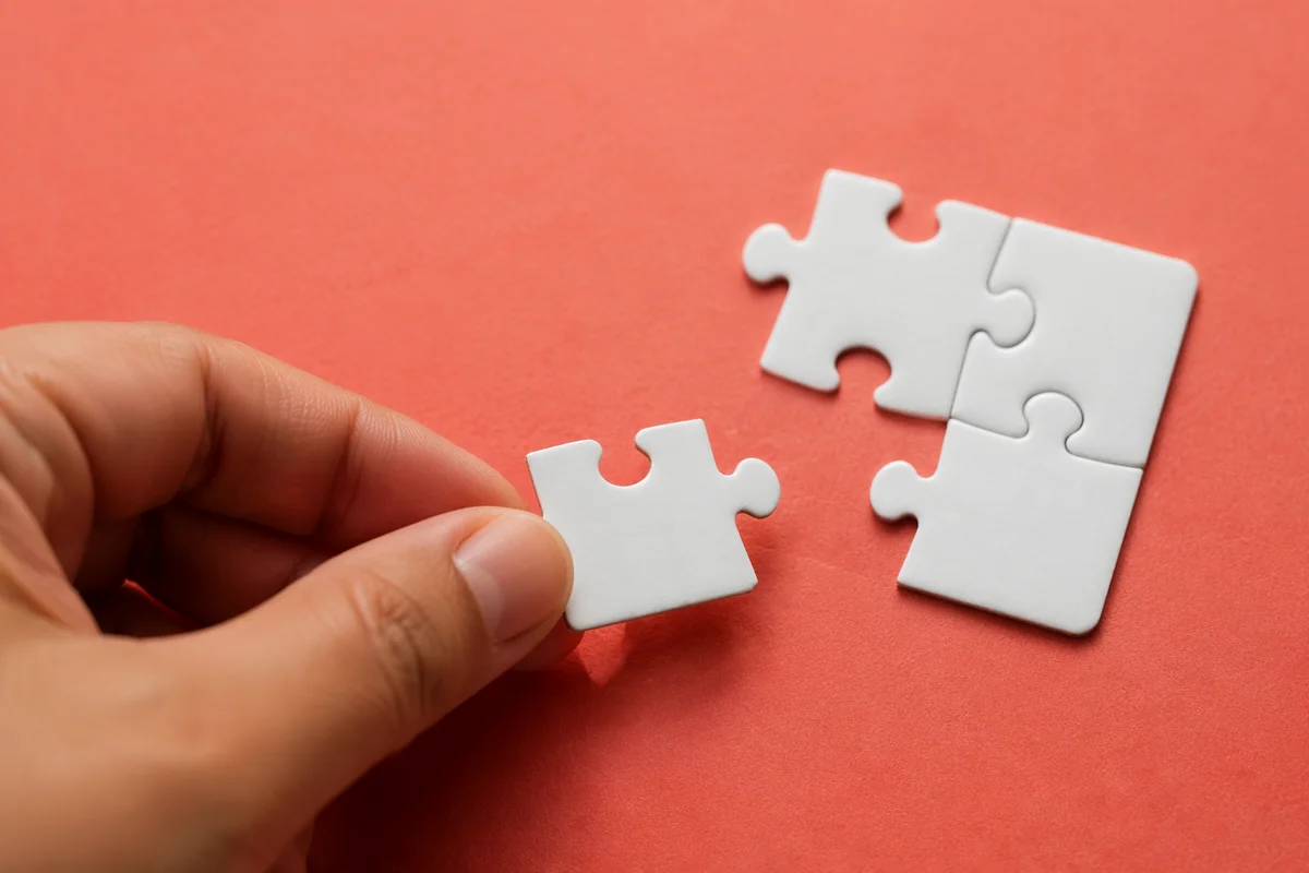 Hand Placing Puzzle Piece for Teamwork