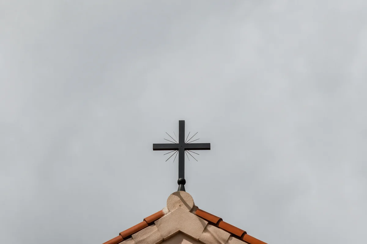 Minimalist Metal Cross on Terracotta Roof