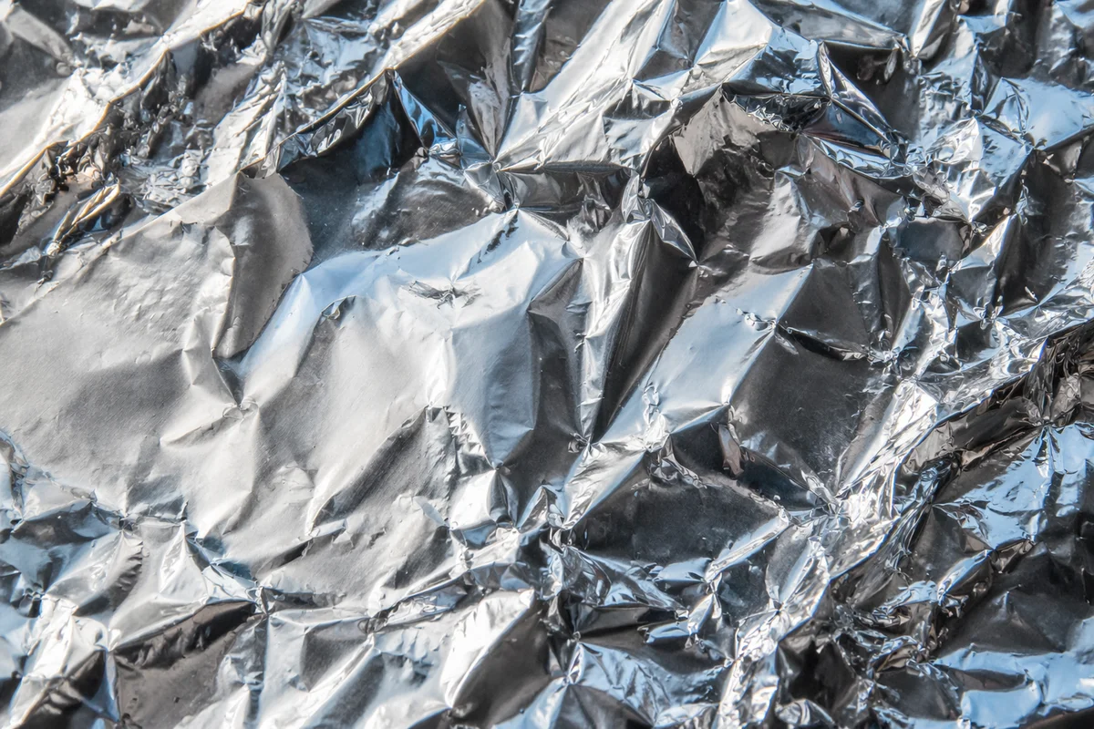 Crumpled Silver Foil Reflective Texture Background