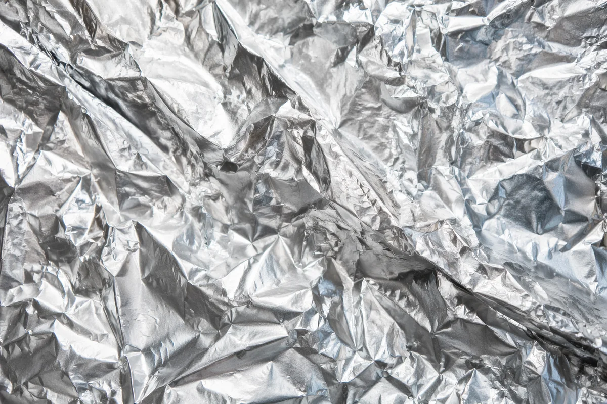 Crumpled Silver Foil Reflective Texture Background