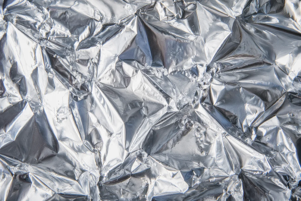 Crumpled Silver Foil Reflective Texture Background