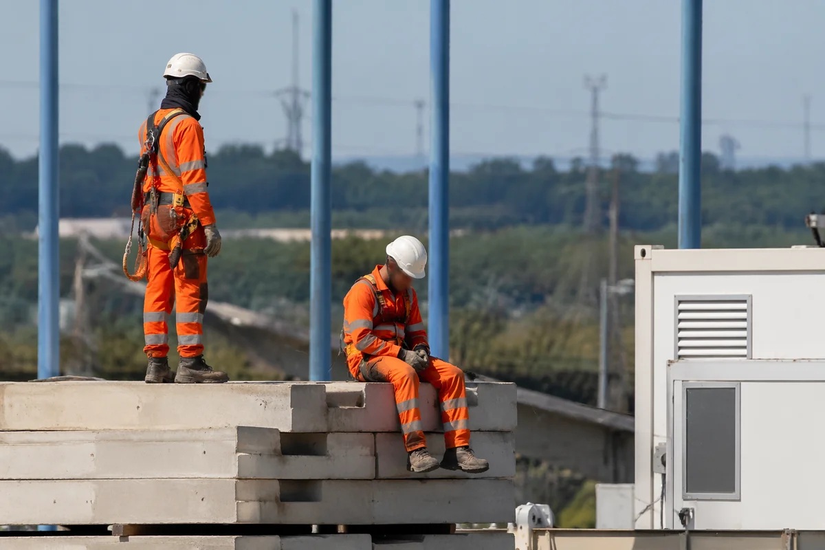 Construction Workers in Hard Hats on Concrete Slabs