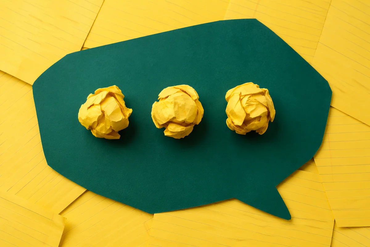 Crumpled Paper Brainstorming on Teal Desk