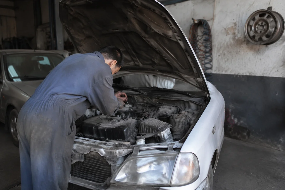 Mechanic Repairing Car in Gritty Garage