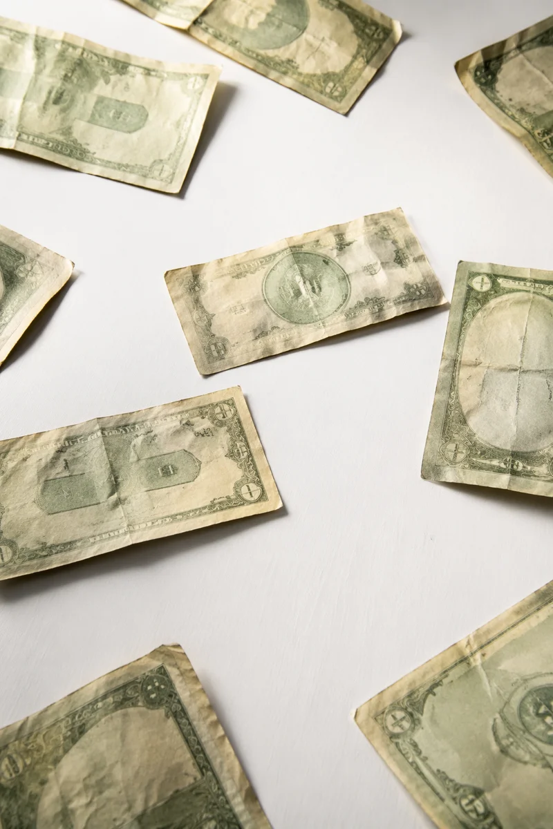 Scattered Green Currency on White Tabletop