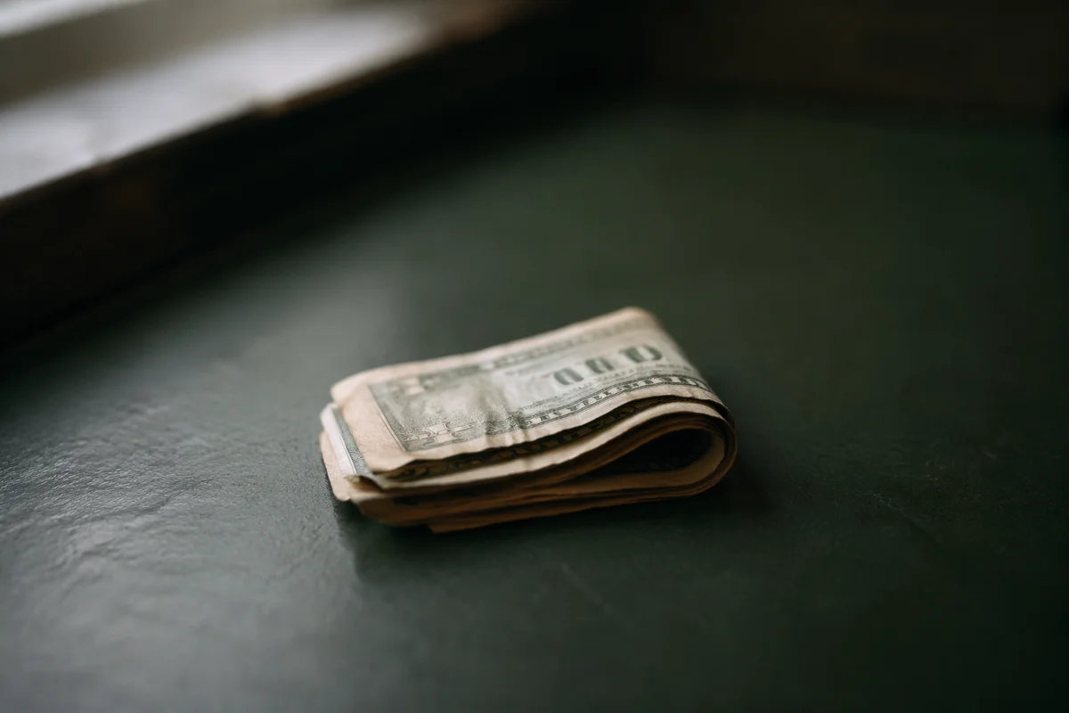 Folded Dollar Bills on Green Tabletop