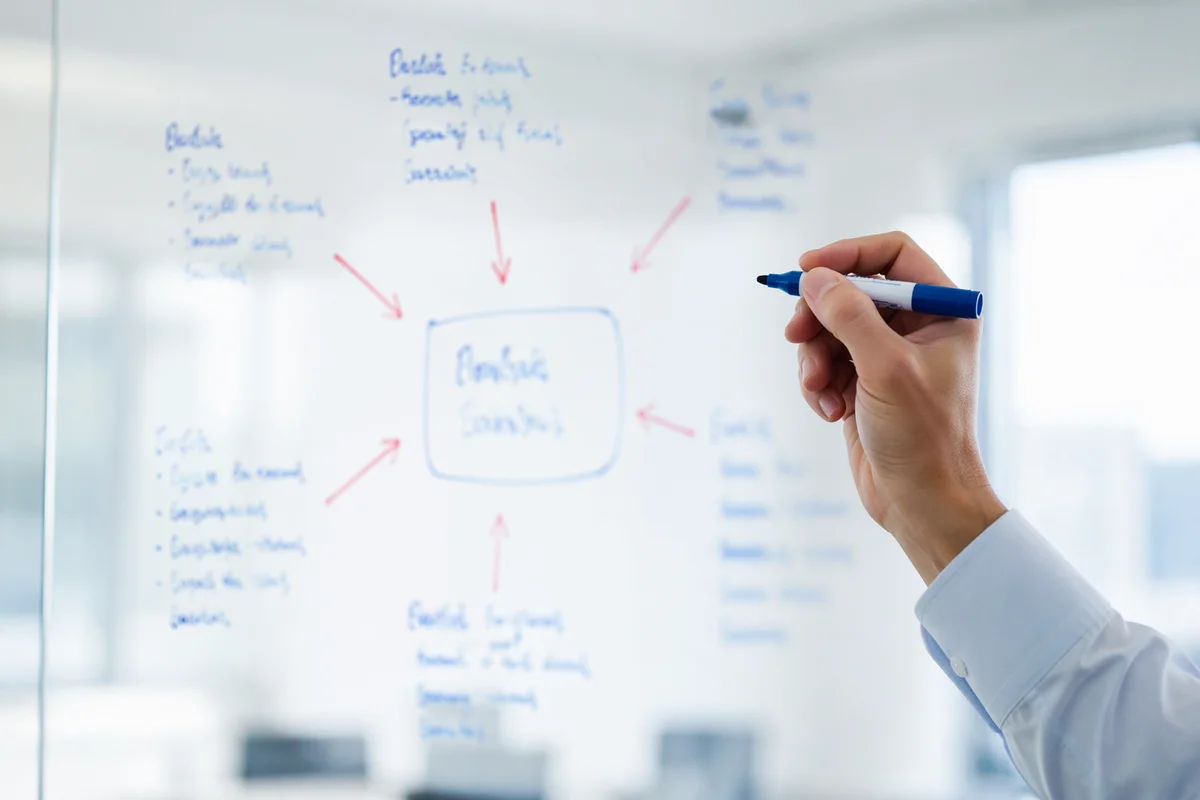 Hand Writing Business Strategy on Glass Board