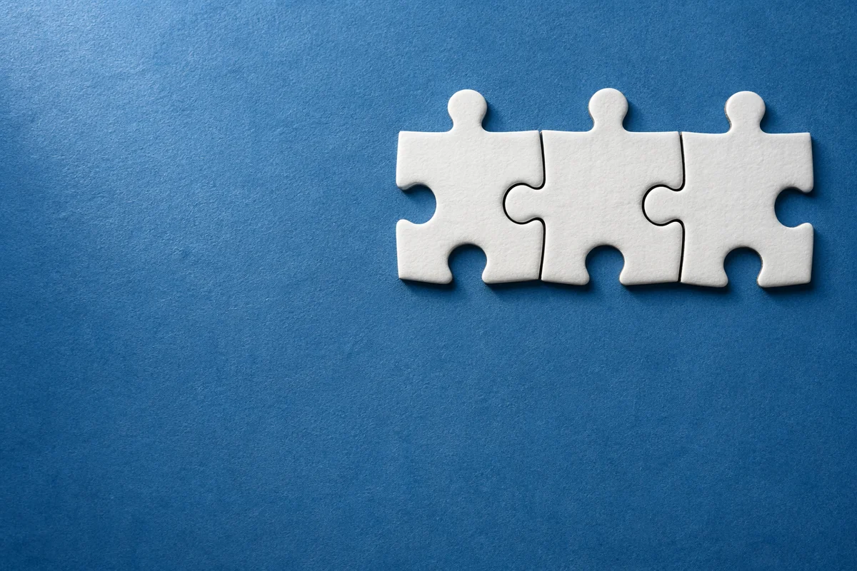 White Puzzle Pieces on Blue Teamwork Background