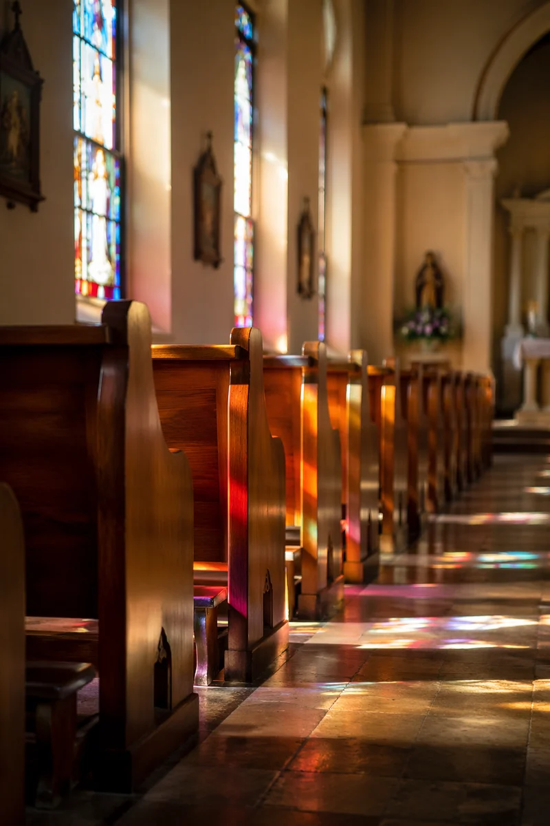 Sunlit Church Pews and Stained Glass