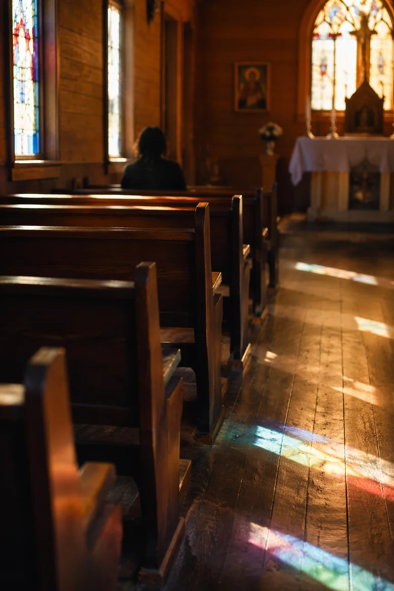 Sunlit Chapel Pews with Stained Glass