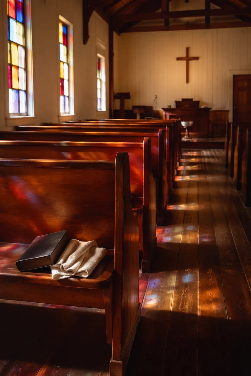 Sunlit Chapel Pews with Stained Glass