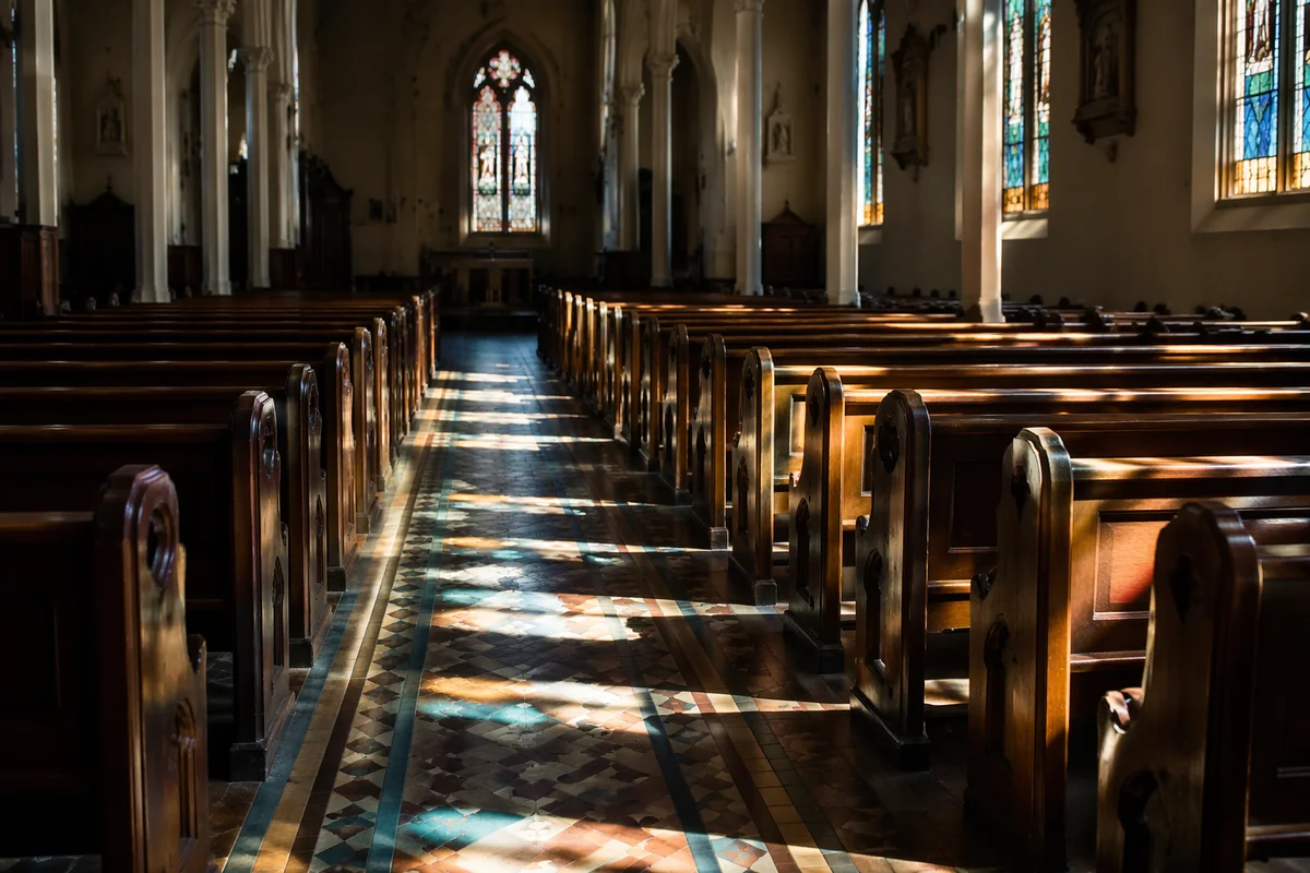 Sunlit Church Pews and Stained Glass