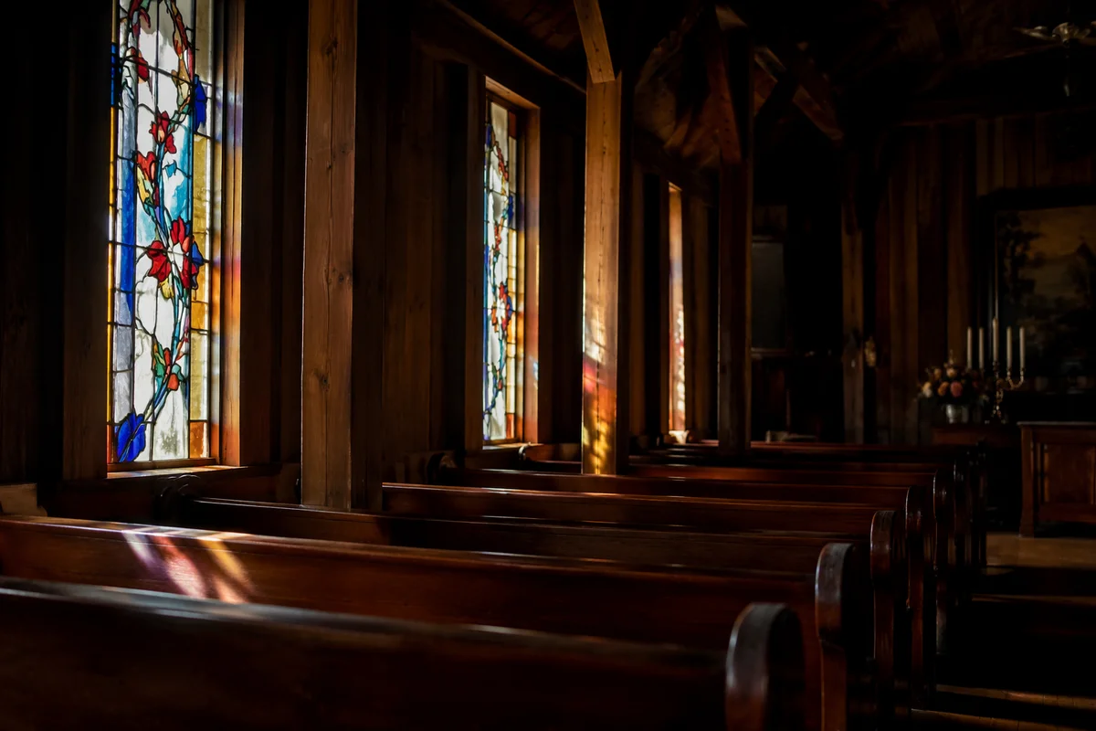 Sunlit Stained Glass Over Chapel Pews