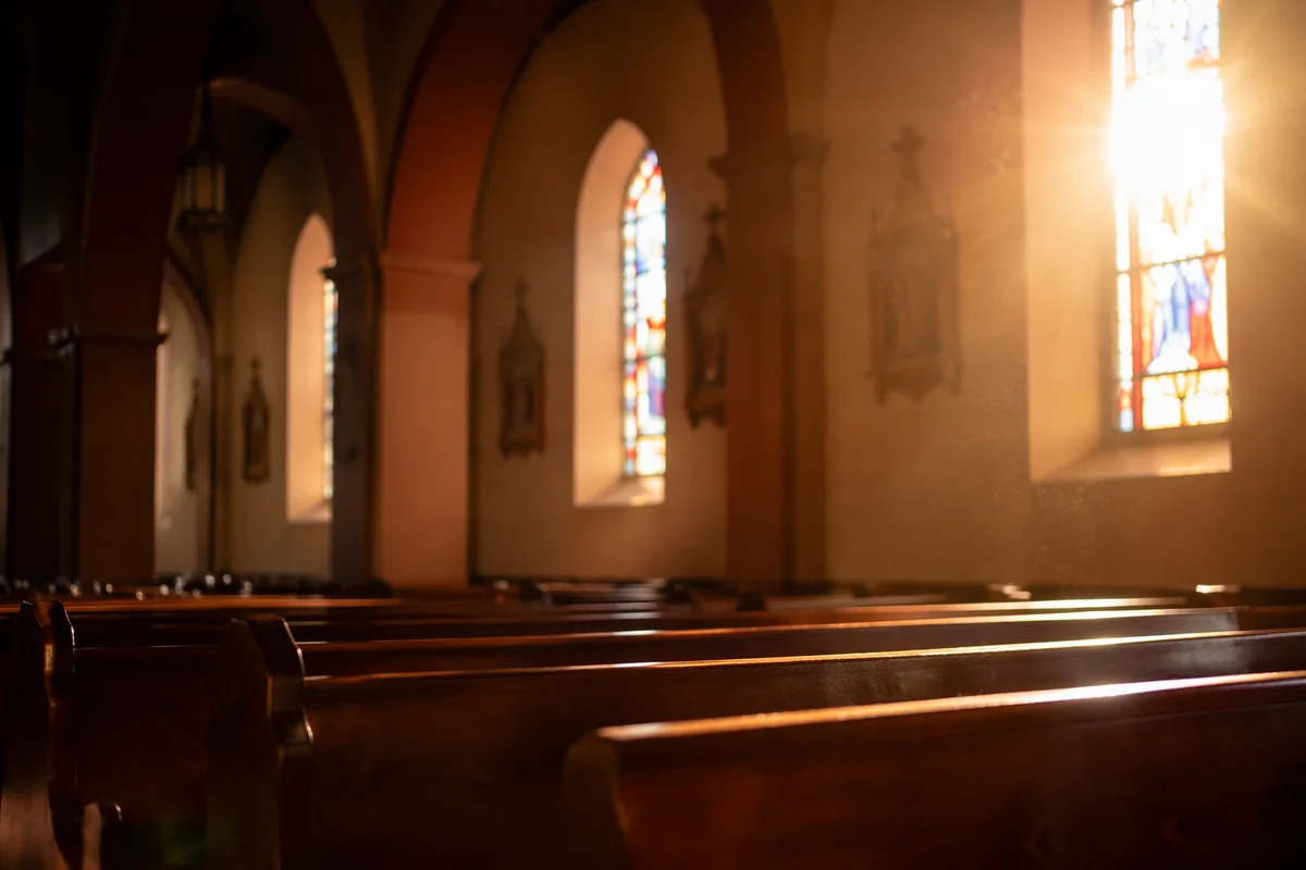Sunlit Church Pews with Stained Glass