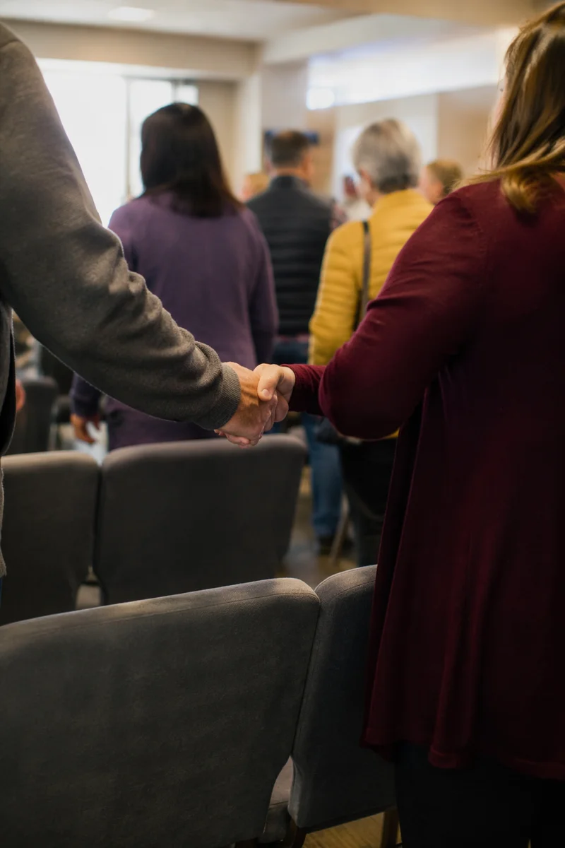 Warm Church Welcome Handshake in Fellowship Hall