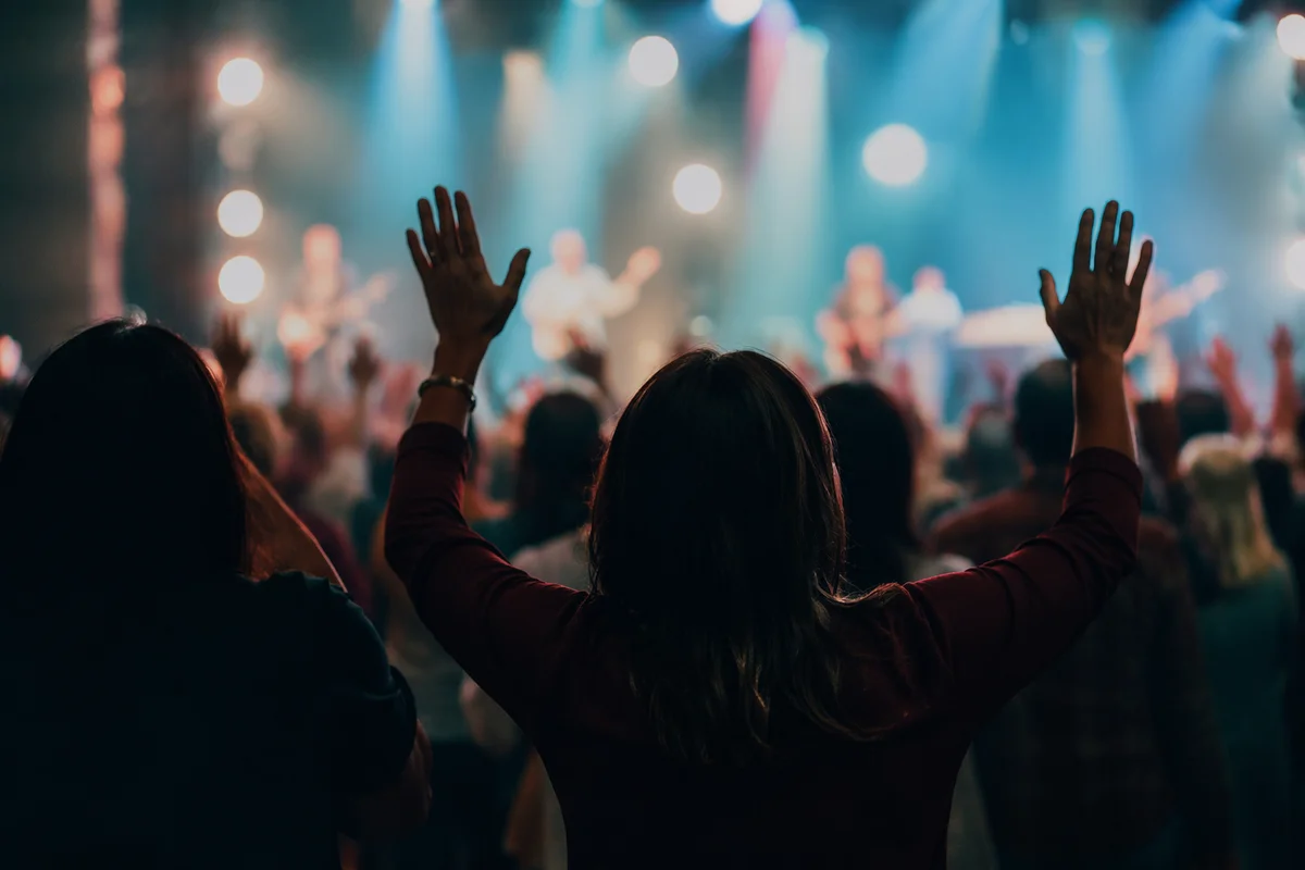 Raised Hands in Church Worship Lights