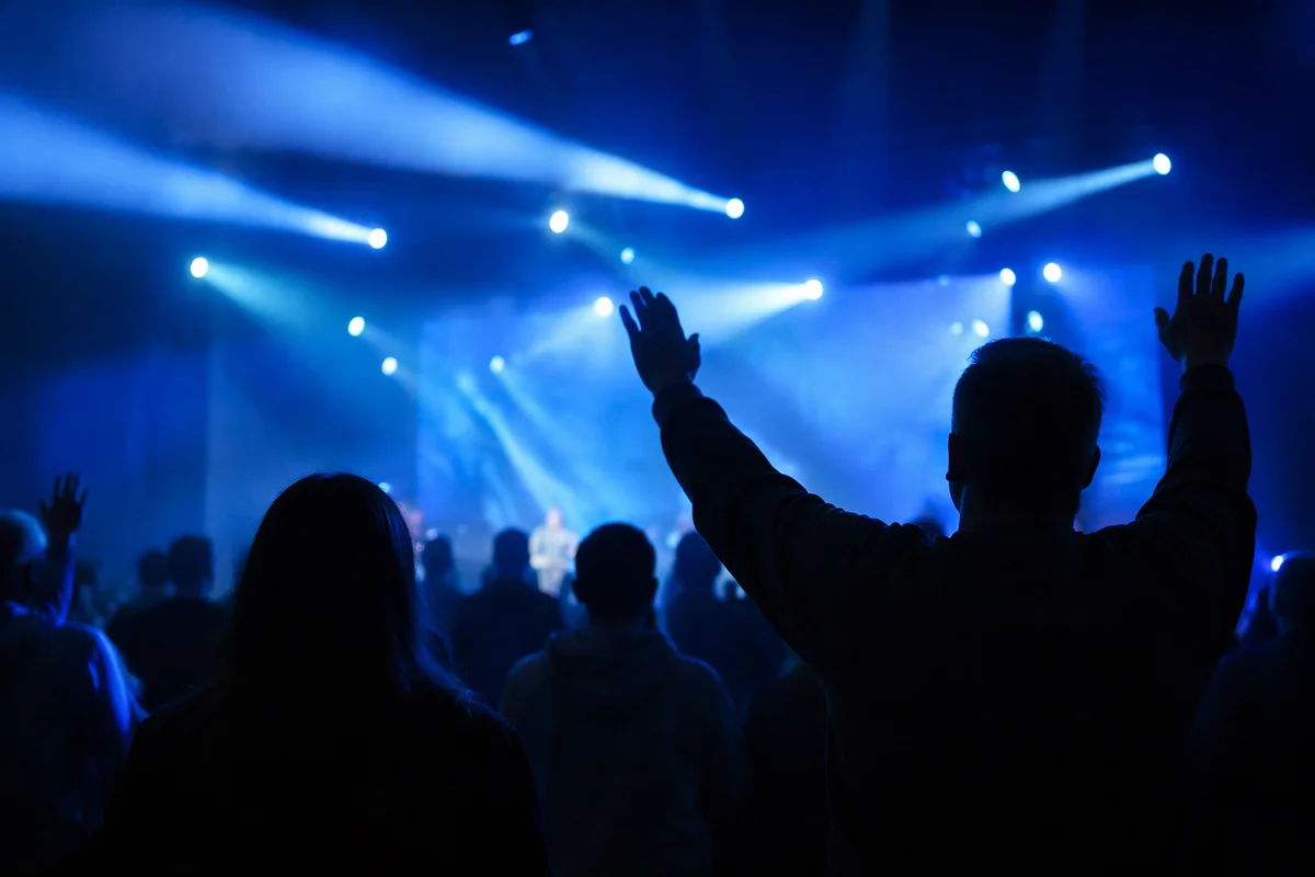 Raised Hands in Blue Worship Lights