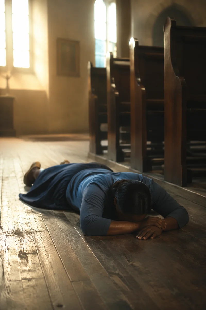 Woman Praying Prostrate on Church Floor