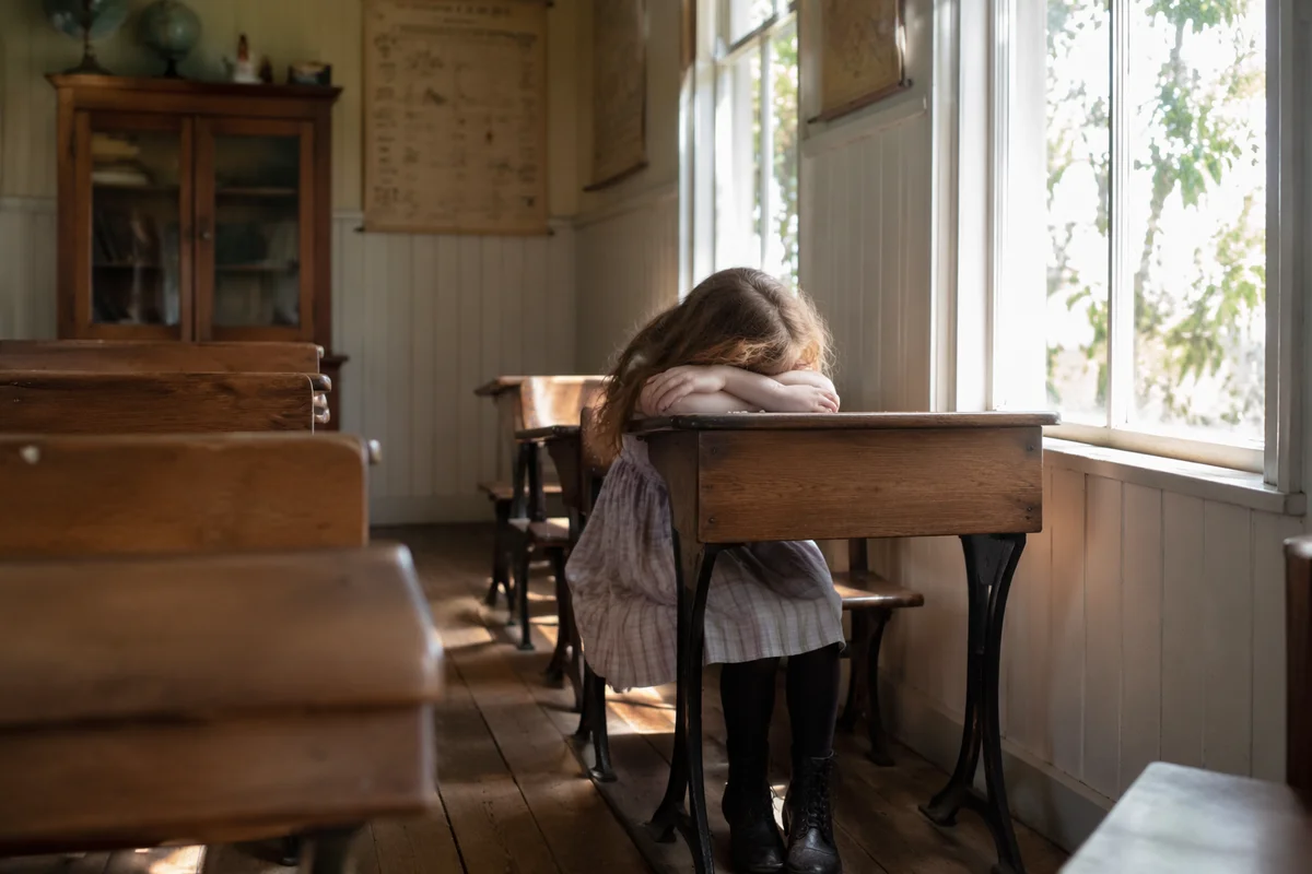 Quiet Student in Sunlit Vintage Classroom