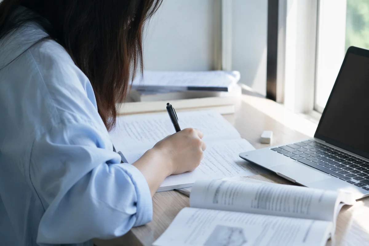 Focused Student Studying with Laptop Notes