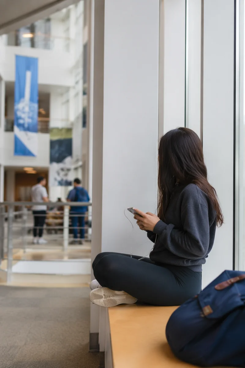 Student Relaxing in Modern University Atrium