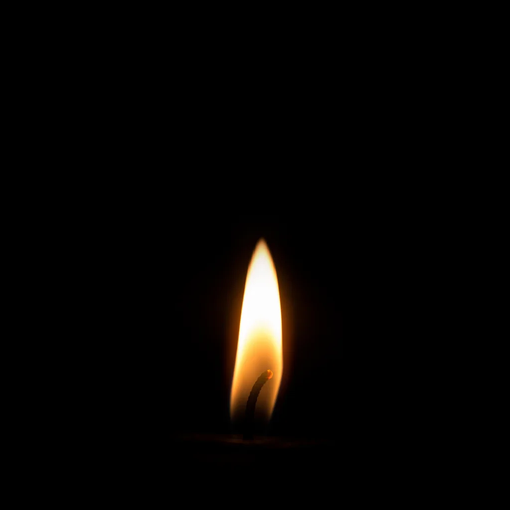 Single Candle Flame in Vast Darkness