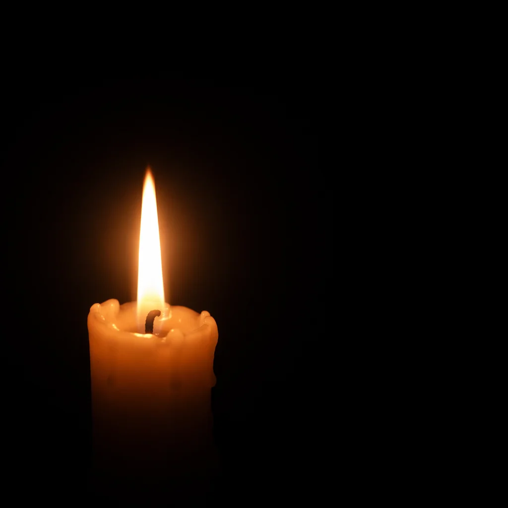 Single Candle Flame in Vast Darkness