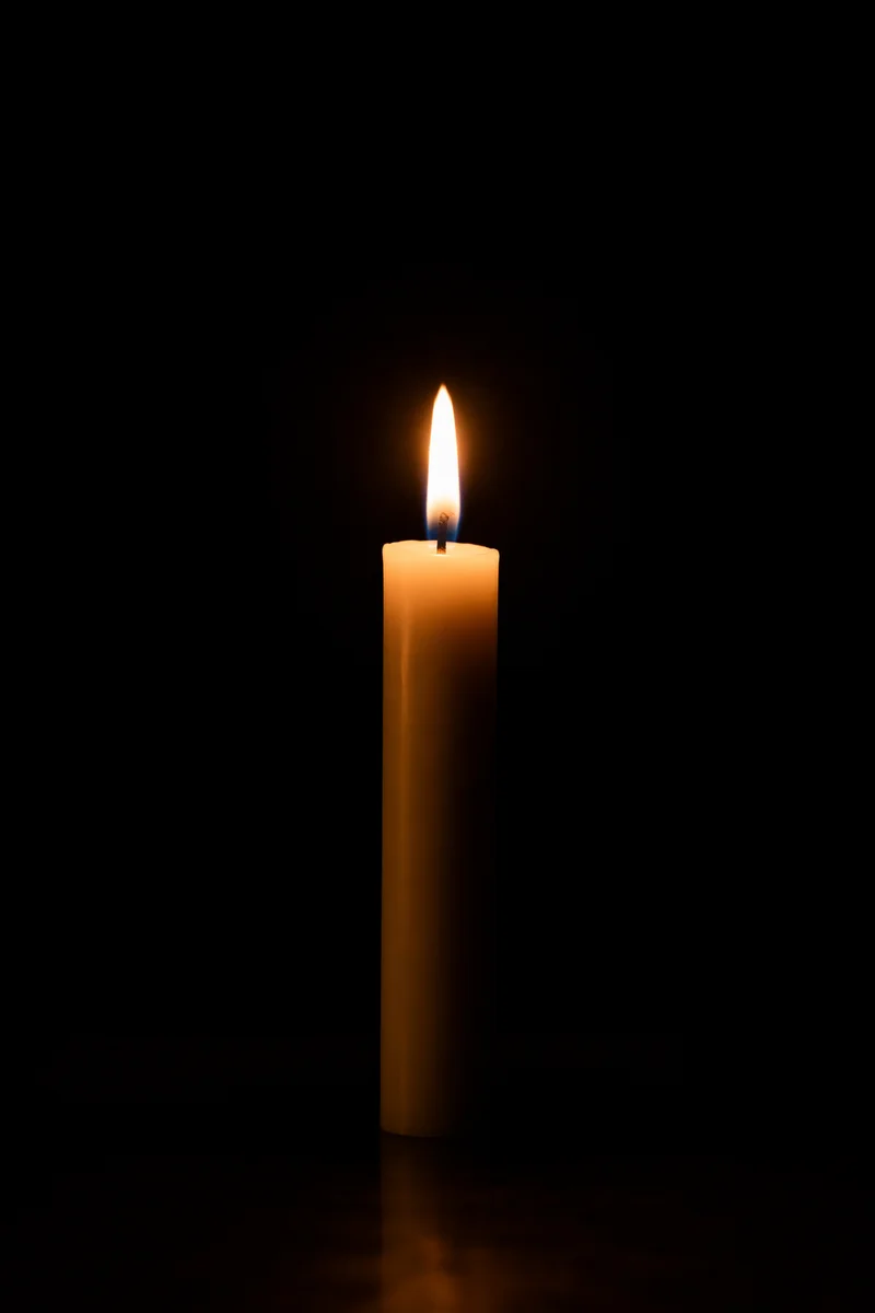 Single Candle Flame in Vast Darkness