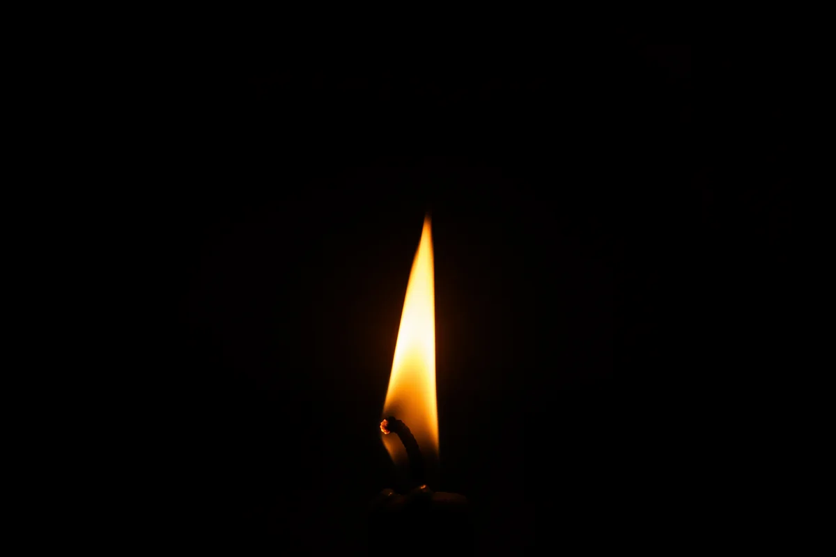 Single Candle Flame in Vast Darkness
