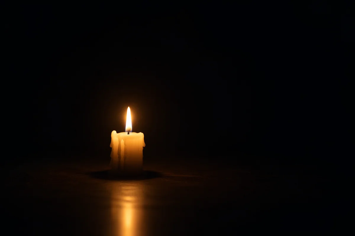 Single Candle Glowing in Dark Room
