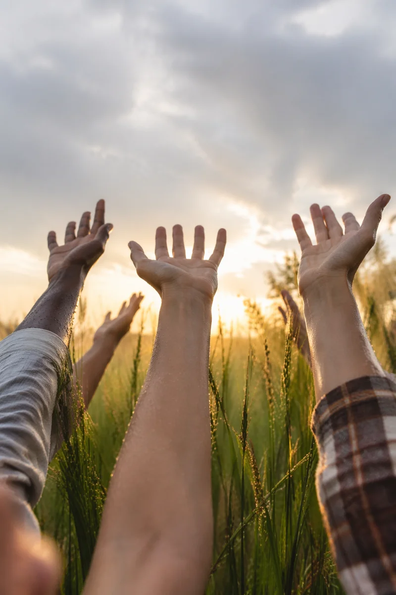 Raised Hands Toward Sunrise Sky