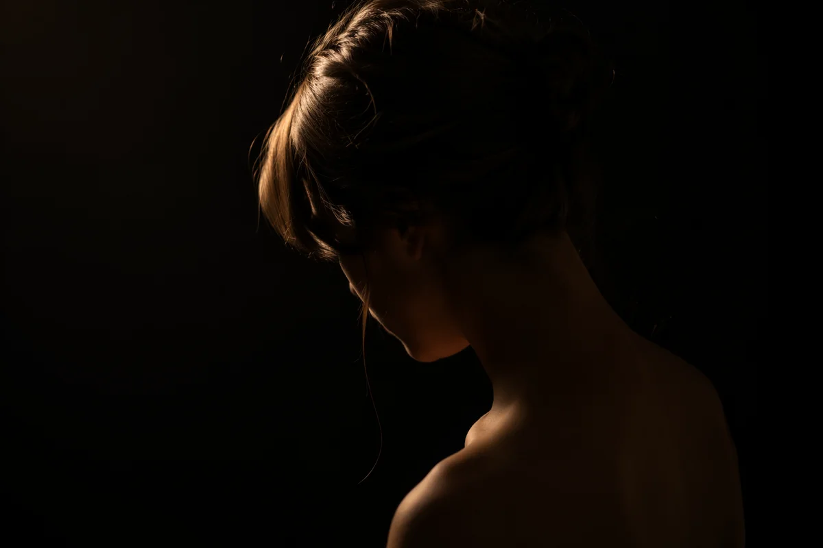 Bowed Head in Gentle Amber Light
