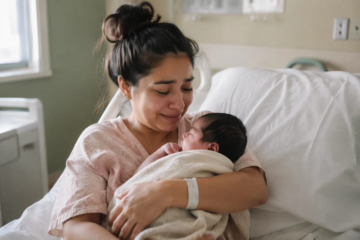 Emotional Mother Holding Newborn in Hospital