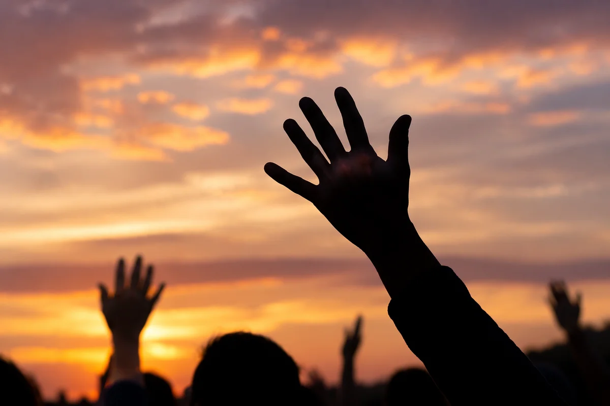 Lifted Praise Hands at Golden Sunset