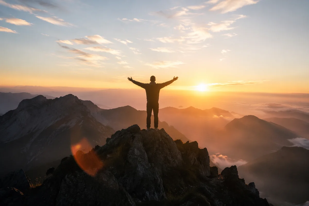Silhouette Victory on Mountain Summit Sunrise