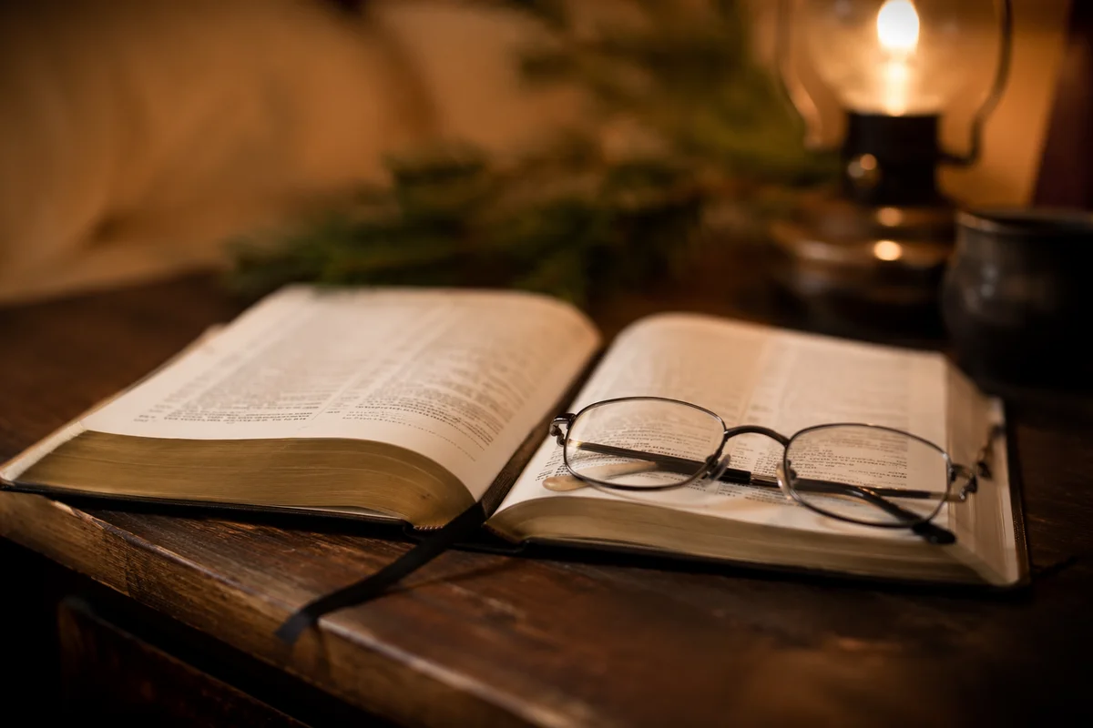 Open Bible with Reading Glasses in Warm Light