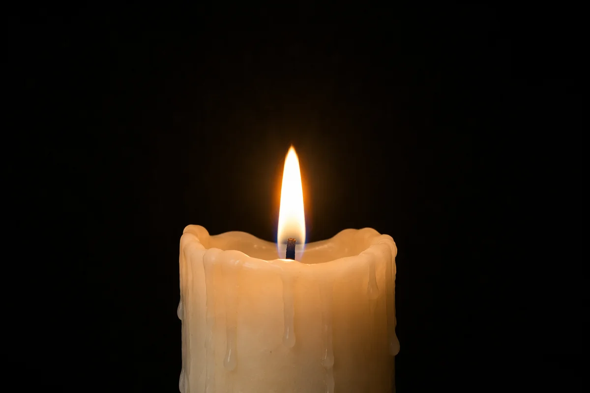 Burning Ivory Candle in Quiet Darkness