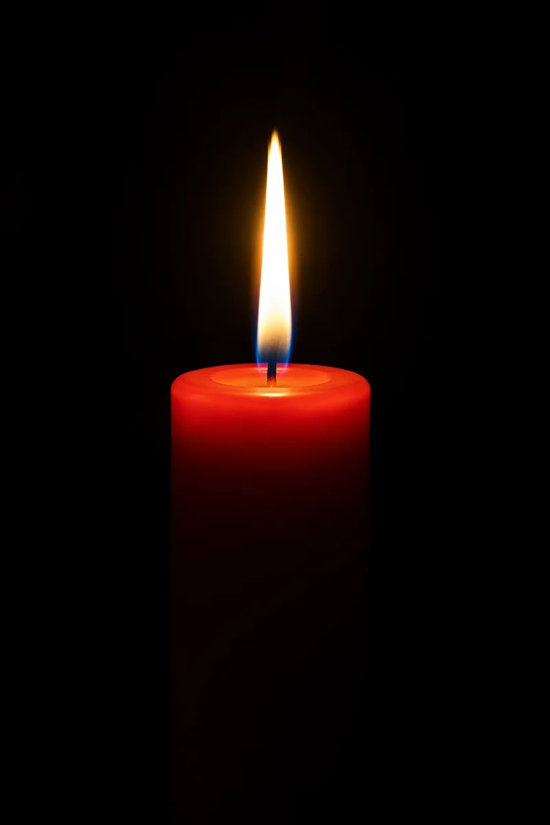Red Candle Flame in Quiet Darkness