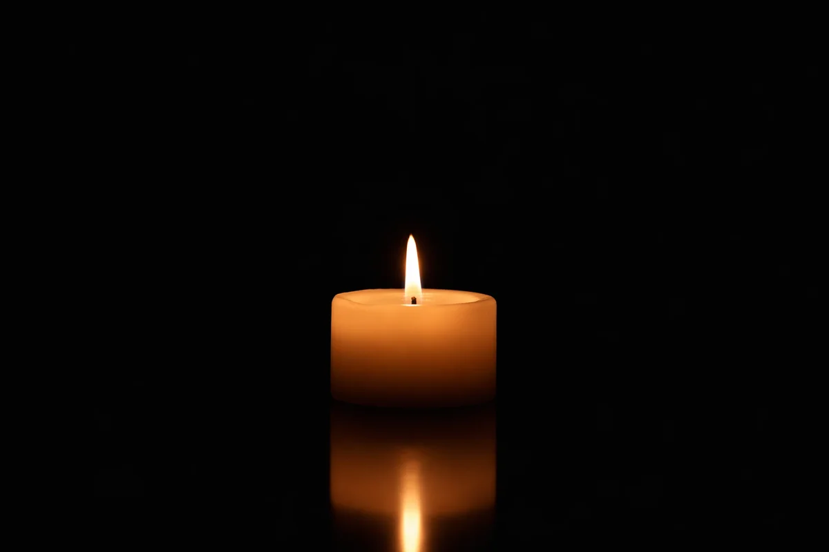Burning Ivory Candle on Dark Background