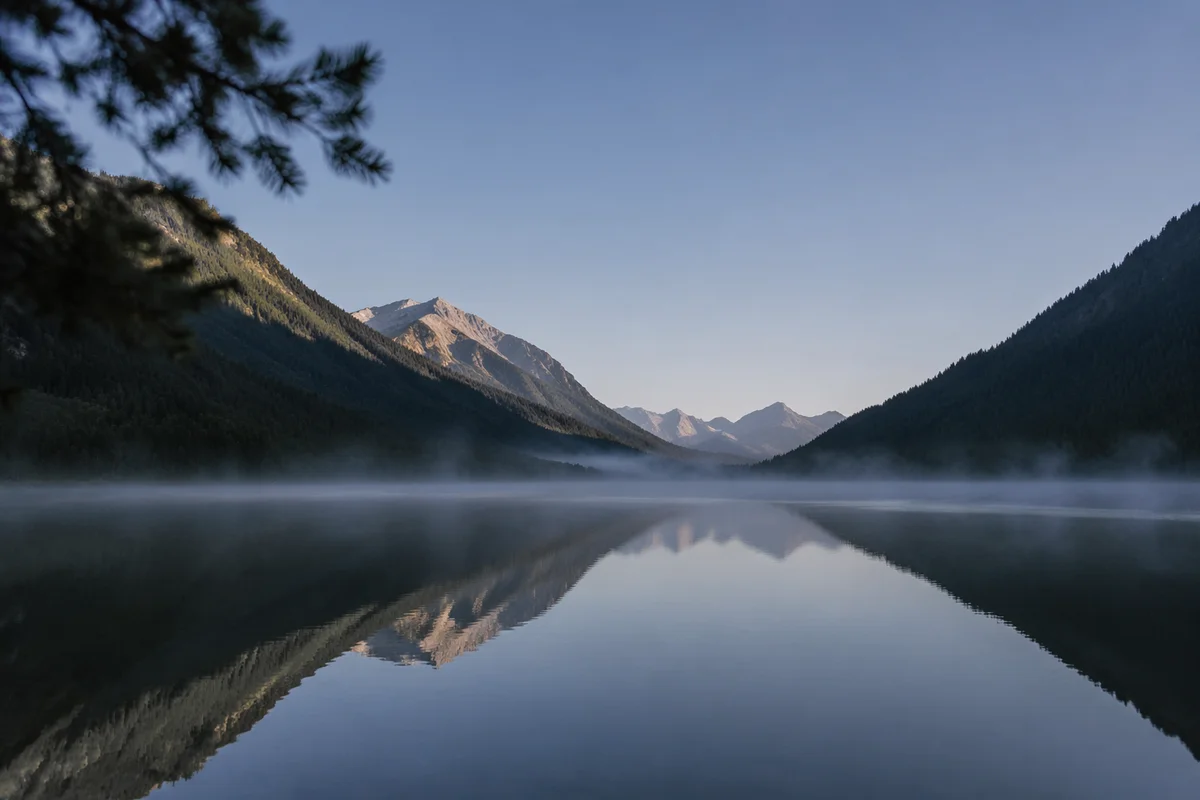 Calm Morning Lake Reflection in Evergreen Mountains