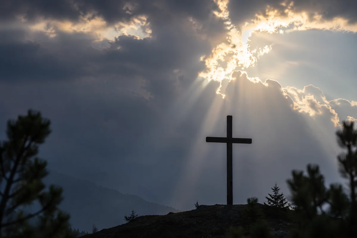 Cross Silhouette Beneath Breaking Light Rays
