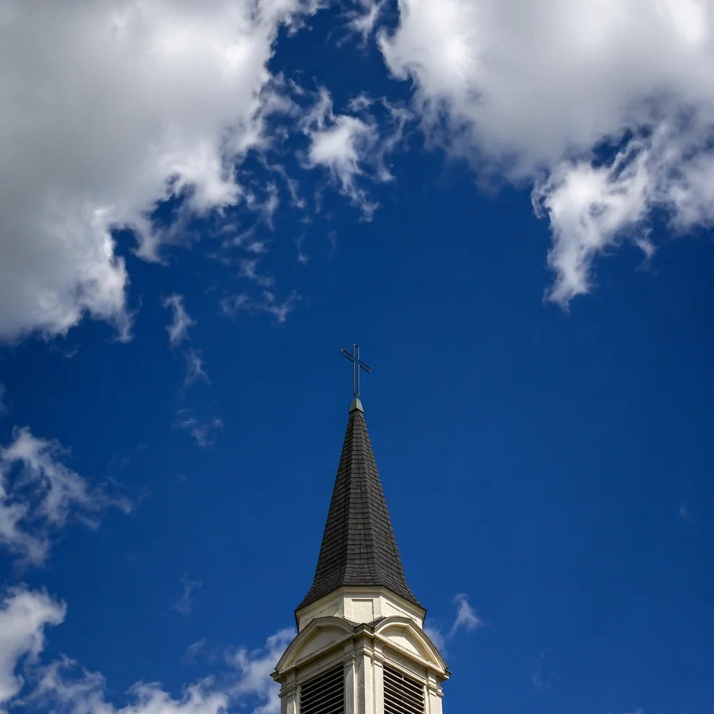 Empty Cross Above Church Steeple and Clouds
