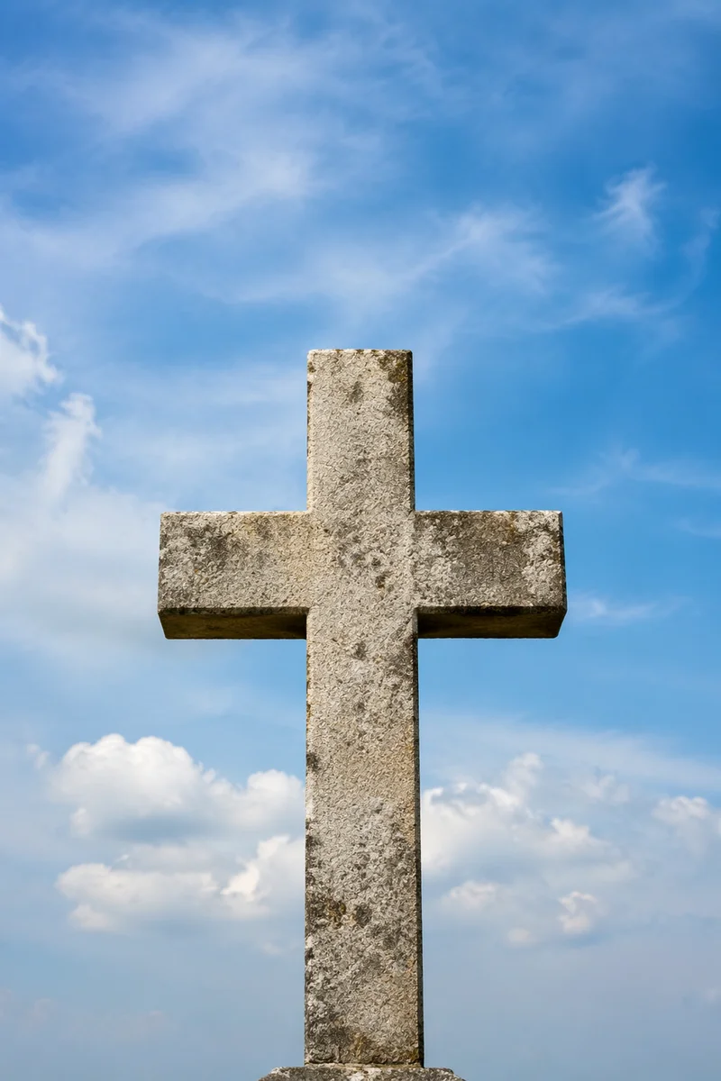 Weathered Stone Cross Beneath Blue Sky