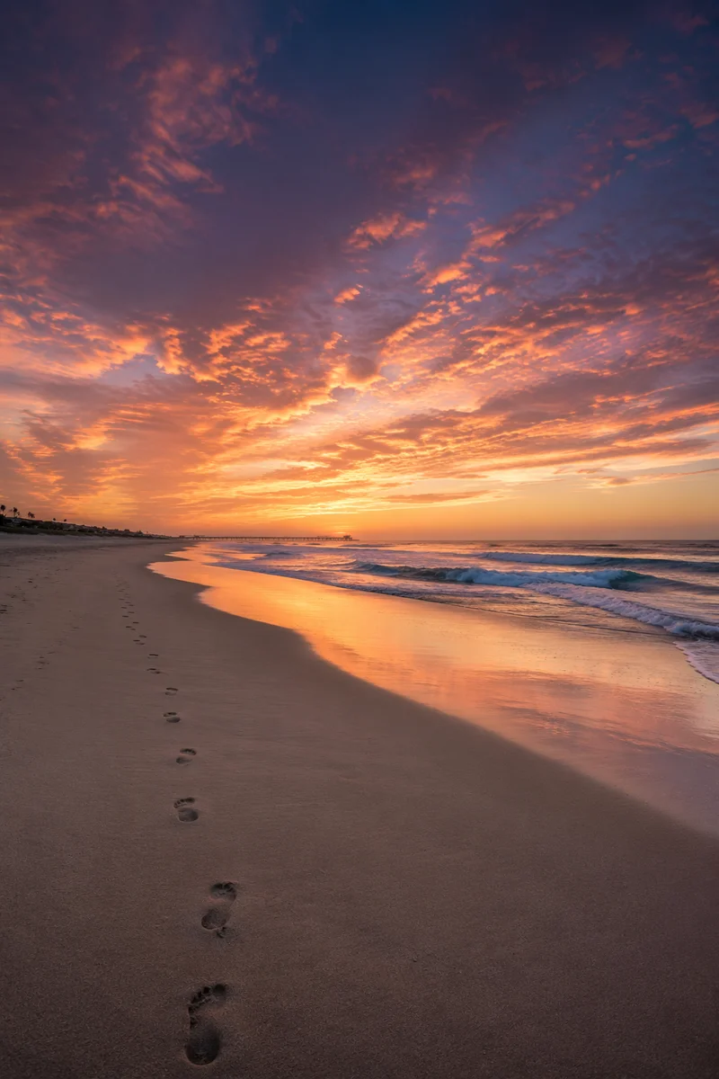Footprints on Sandy Beach at Sunrise