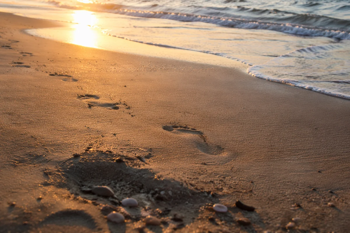 Peaceful Footprints in Sand at Sunrise