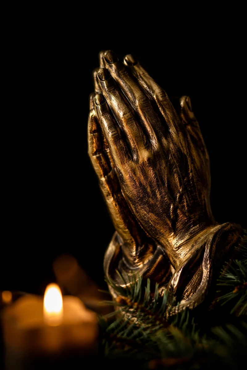 Candlelit Bronze Praying Hands with Evergreen