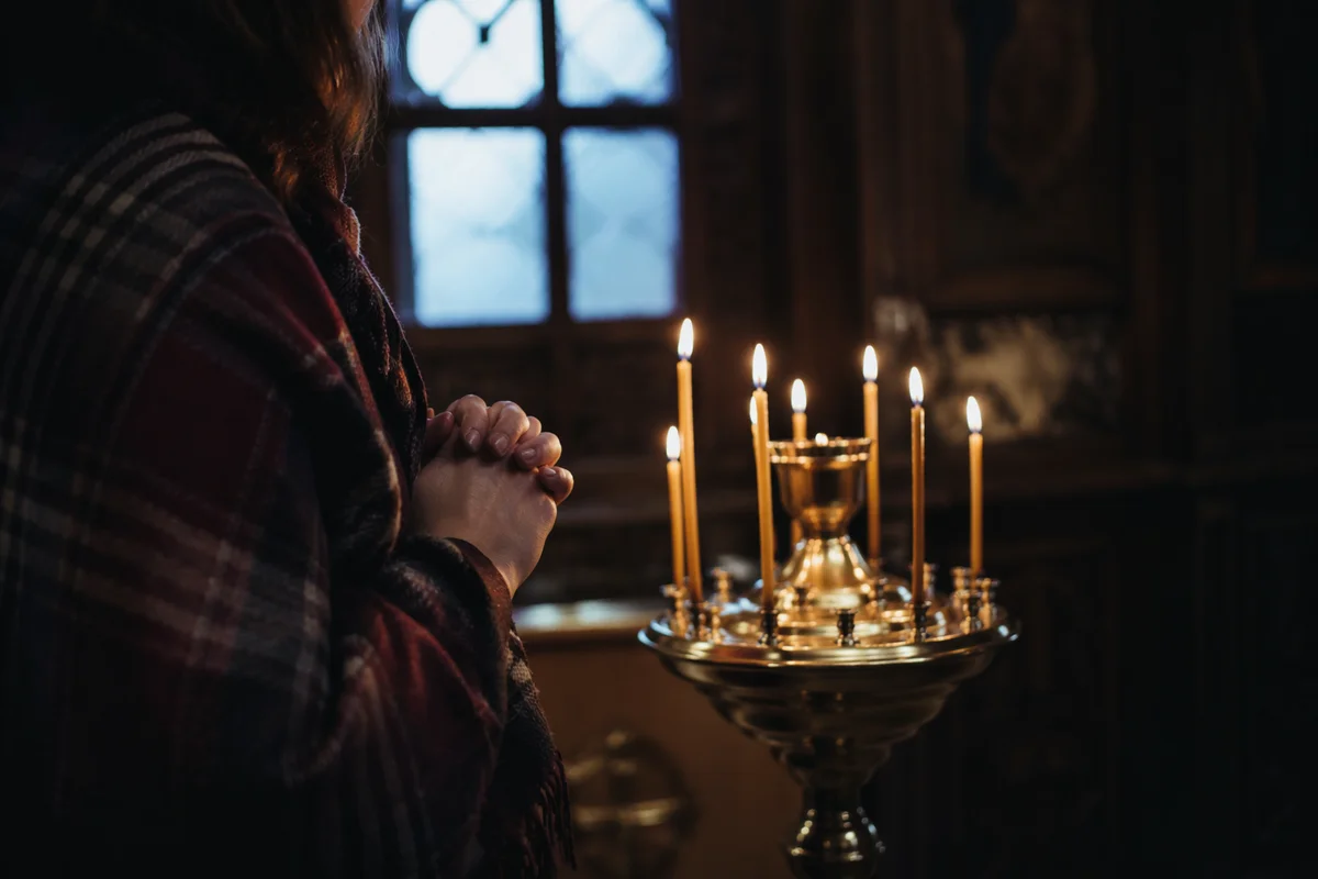 Folded Hands in Prayer by Candlelight