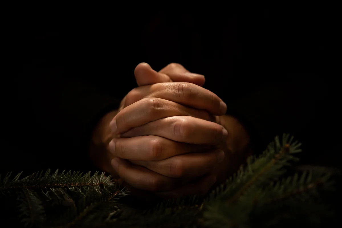 Praying Hands in Soft Evergreen Light